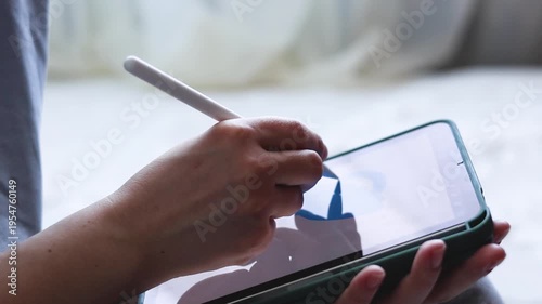 A woman draws on a tablet. Hobbies and entertainment.