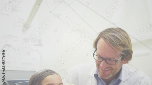 Animation of network of connections over caucasian girl getting her teeth examined by male dentist