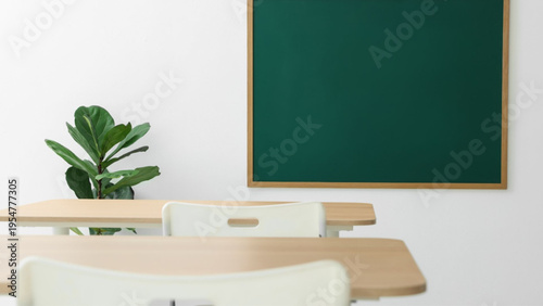 Empty classroom with green chalkboard wooden desks and a plant on a table