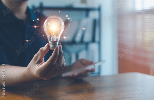 Hand holding glowing light bulb symbolizing innovation, creative ideas, inspiration, problem solving, and business strategy with modern technology and digital thinking concept.