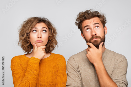 Two people thinking while looking up in a blank space
