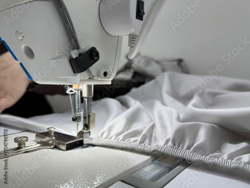 Konstfotografi Industrial sewing machine stitching elastic seam on white fabric close-up