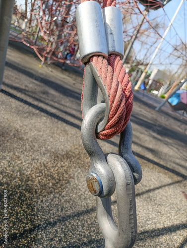 Fotografie Steel chain link and shackle with red rope attachment close-up, outdoor rigging connection detail