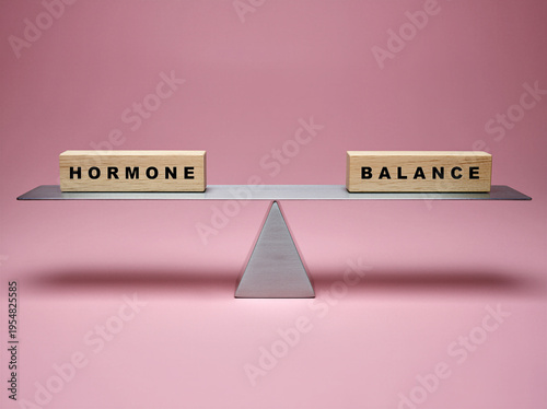 simple fulcum scales with two wooden block, visually showing the imbalance in using the words Hormone balance embossed one word one each block