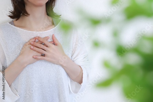 胸に手を当てる女性