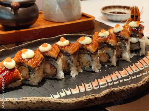 Glistening eel rests atop rice and creamy sauce