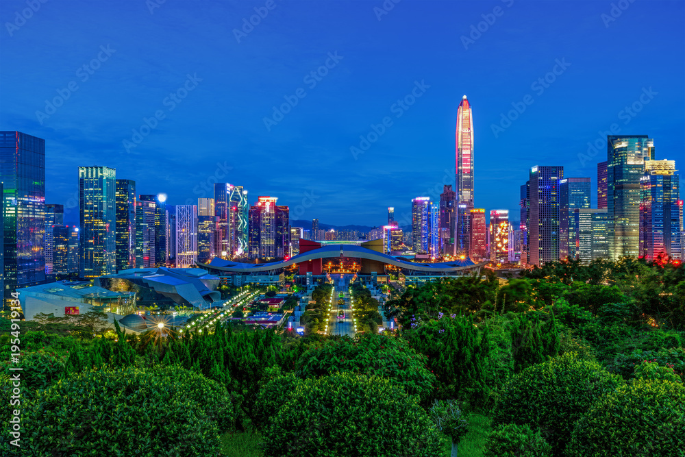 Obraz premium Blue hour skyline of Shenzhen civic center with illuminated skyscrapers and urban greenery in Futian district, China.