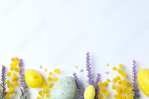 Easter composition with festive eggs and spring mimosa flowers on white background
