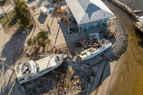 Billede på lærred Capsized sunken sailing boat left forsaken on shallow bay waters after hurricane