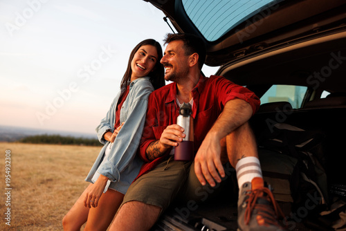 Couple going for summertime road trip taking a break on a mountain viewpoint
