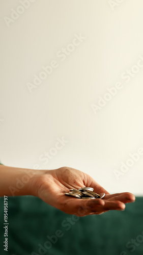 Dirty hand holding a few small coins. Poverty, financial crisis, and social inequality concept. Beggar or poor person asking for help and money with copy space