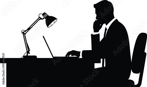 Silhouette of businessman working at desk with lamp