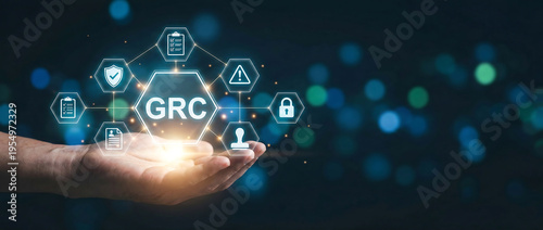 Hand holding glowing GRC governance risk compliance hologram icons with futuristic digital background and cybersecurity elements