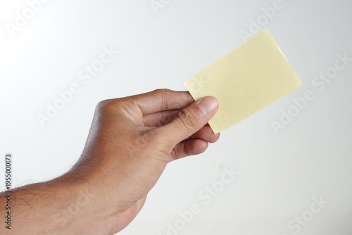 Male Hand Holding Blank Yellow Card Mockup on White Background