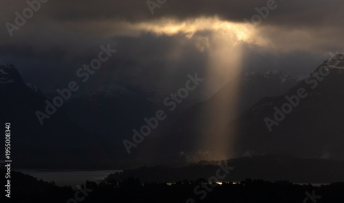 Tableau sur toile Single sun ray over Lake Nahuel Huapi after rain with first snow on Andes, view