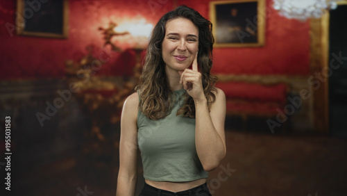 Принти на полотні Woman pointing finger toward camera in ornate museum gallery interior; connection joy invitation engagement