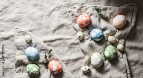 Colorful Easter eggs arranged on a textured linen background. The eggs are in pastel shades of blue, pink, green, and white, with some small decorative elements.