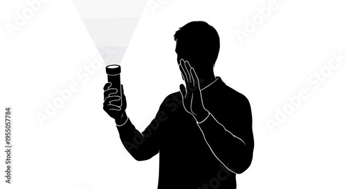 Silhouette of a person holding a flashlight and shielding eyes from bright light
