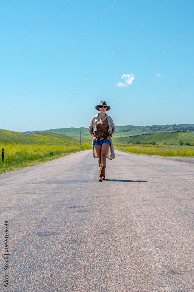 Obraz premium Lone figure walks down a wide, open road