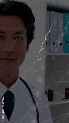 Standing Japanese physician wearing lab coat and stethoscope in medical office with binders overlay
