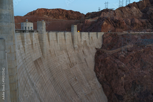 The towering downstream wall of Hoover Dam overlooking the Colorado River, framed by the rugged cliffs of Black Canyon.