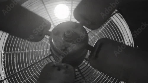 Industrial fan blades spinning in slow motion, creating a mesmerizing black and white visual, high angle close up