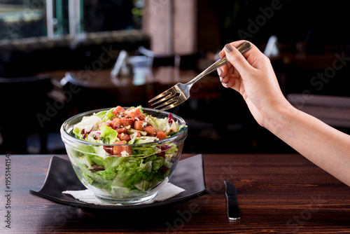 фотографія young woman eating delicious tuna salad in a fancy restaurant, low-calorie nutri