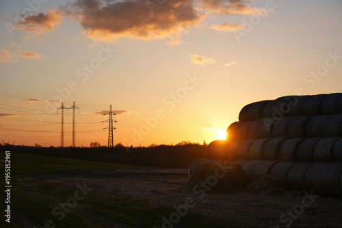 Warm Evening Light Over Farmland with Hay Bales