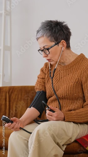 Senior woman checking blood pressure at home