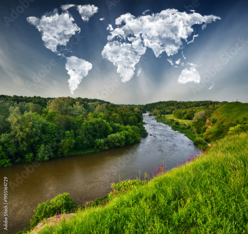 clouds in the form of a world map over a picturesque river. travel and landscape concept. spring meadow