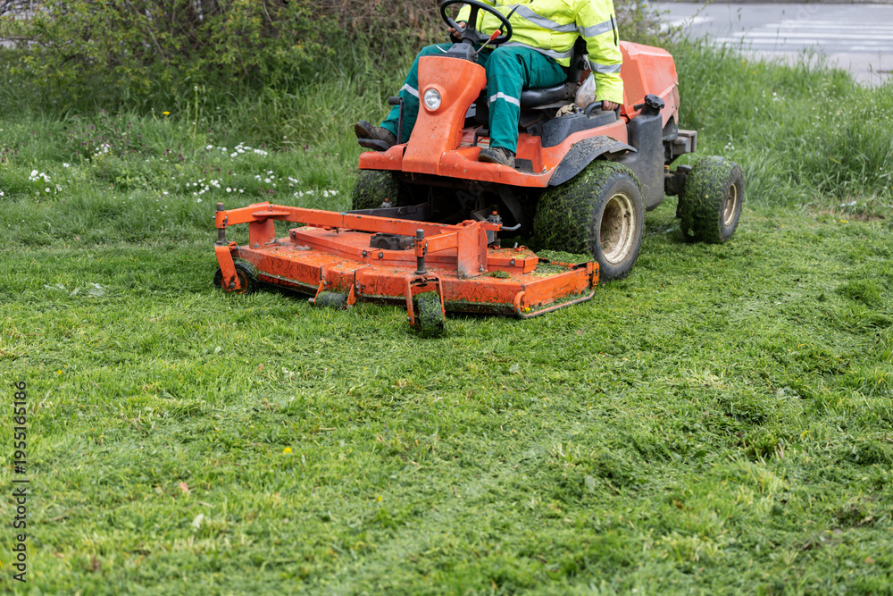 Obraz premium Front view of ride on mower cutting freshly trimmed lawn