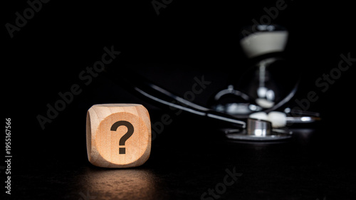 Medical uncertainty concept with question mark on wooden block and stethoscope. Healthcare diagnosis, time and health insurance questions.