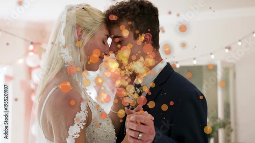 Bride and groom pressing foreheads, holding hands at wedding, causing gold particles appearing