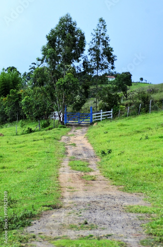 In the countryside, the wooden gate painted blue on the farm on a sunny afternoon in the interior of Minas Gerais.