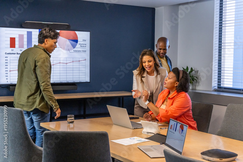 Bild auf Leinwand Diverse coworkers in business attire collaborating in conference room with lapto