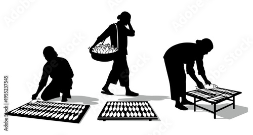 Silhouettes of people drying fish outdoors on racks a basket of fish