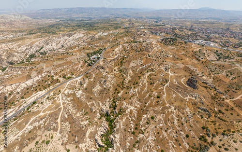 Wallpaper Mural Goreme, Nevsehir, Turkey. Expansive aerial view of arid Cappadocia landscape under scorching summer sun, with parched terrain, distant plateaus and heat haze on horizon. Aerial view. Torontodigital.ca