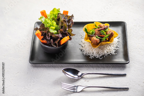 Schilderij op canvas A delicious and colorful meal with a crispy shell filled with stir-fried vegetables and meat, served with a side salad