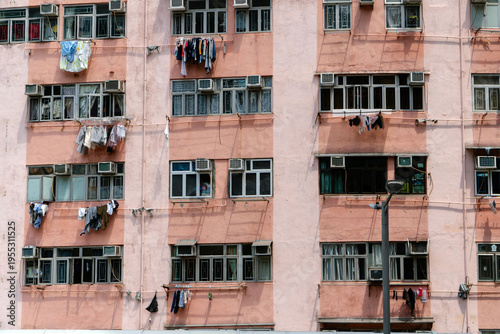 Residential building facade with hanging laundry and air conditioners in Hong Kong