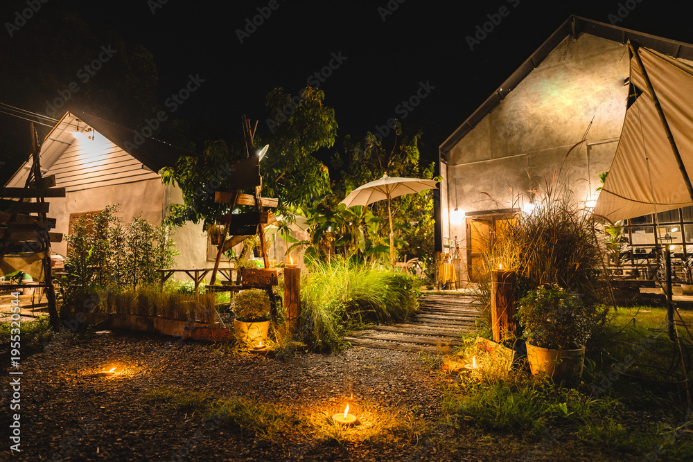 Fototapeta premium Camp party outdoor holiday relax atmosphere with warm lighting rustic building garden path and cozy night setting create peaceful retreat for friends to unwind and enjoy nature together