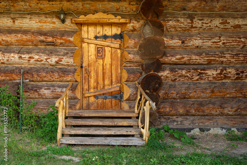 A vintage log warehouse with a closed door made of thick planks. A close-up of the log wall.