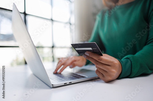 Canvastavla A person engages in online shopping using a laptop and credit card, showcasing modern technology and consumer behavior