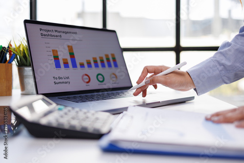 A close-up view of an engaged professional utilizing a laptop to analyze project management data, highlighting the importance of task organization and effective workflow.