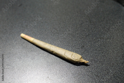 Joint of weed on dark surface September 2024 rolled cannabis cigarette on textured black background