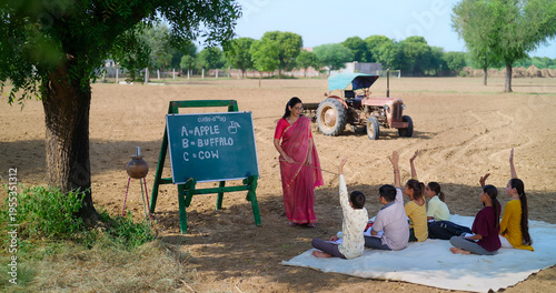 Canvas Print Indian mature adult female lady talk speak teach to villager child day under tre