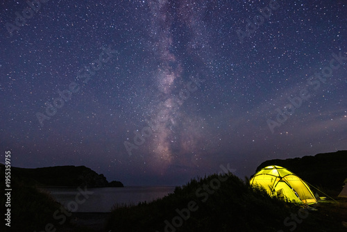 Tourist tent near the sea under the night sky with milky way.