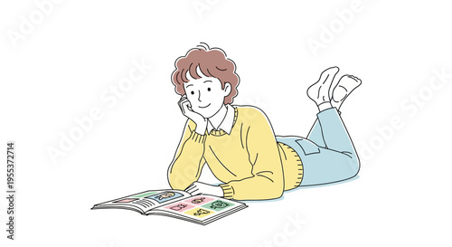 young boy reading a book lying down.