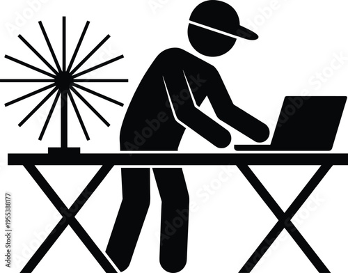 Black silhouette of a craft worker using a laptop on a table with a spinning wheel for textile production or weaving