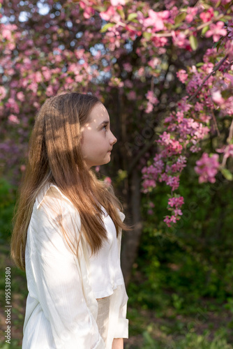 Konstfotografi Portrait of young beautiful girl posing near blossom tree with pink flowers