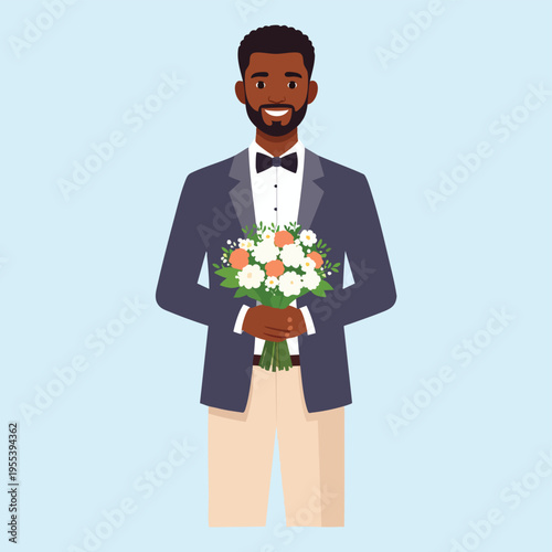 A smiling dark-skinned man in a tuxedo holds a bouquet of flowers indoors.